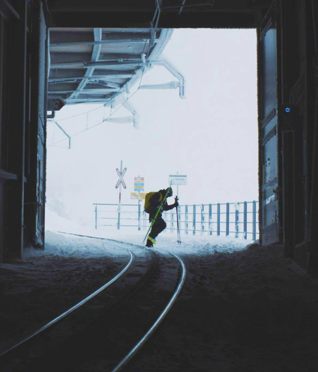 Teaser Bild für den Film von Mustafa-Ceylan_Ciao Fußballplatz, hallo Snowpark!_Ein Skifahrer steht am Ende eines Tunnels und geht über die Gleise. Der Hintergrund ist Hell der Vordergrund ist ein Tunnel und dunkel. © ┬®_Mustafa Ceylan